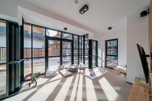 a living room with large windows and a table at Lipowy Dwór in Zakopane