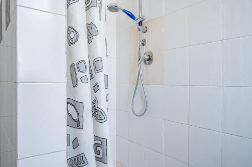 e bagno con tenda da doccia e soffione. di Parma Centro Torri Huge Apartment x6 a Parma