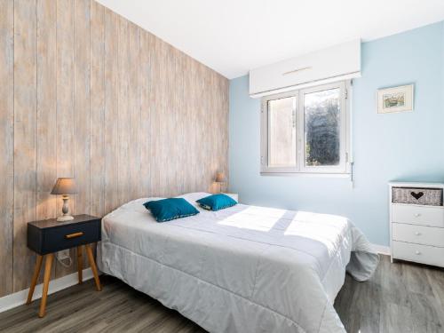 une chambre avec un grand lit aux murs bleus dans l'établissement Apartment Les Ecureuils by Interhome, à La Palud