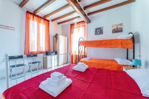 a bedroom with a large red bed with towels on it at Parma Centro Torri Huge Apartment x6 in Parma