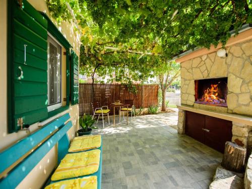 d'une terrasse avec une cheminée, une table et des chaises. dans l'établissement Holiday Home Taja by Interhome, à Split