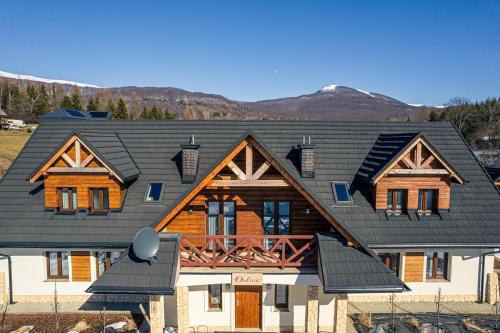 a house with a black roof at Apartamenty Otulina in Wetlina