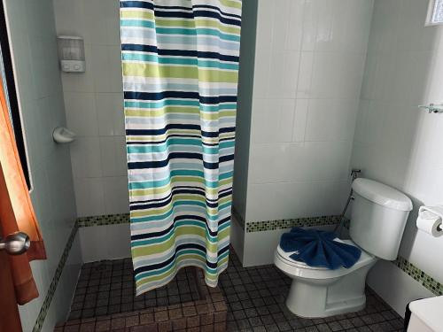 a bathroom with a shower curtain and a toilet at Smile Home in Patong Beach