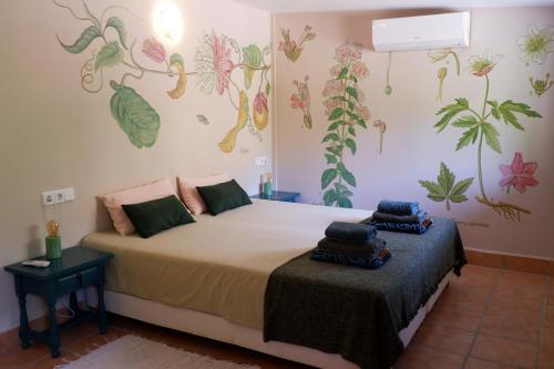 Un dormitorio con una cama y una pared con plantas. en Vegan Guesthouse Finca Pereila en Coín