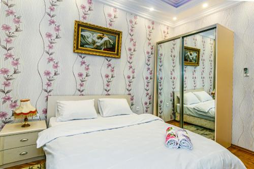 - une chambre avec un lit blanc et un miroir dans l'établissement Apartmet Kolorit, à Baku