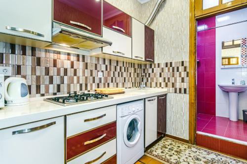 Il comprend une cuisine équipée d'un lave-linge et d'un évier. dans l'établissement Apartmet Kolorit, à Baku