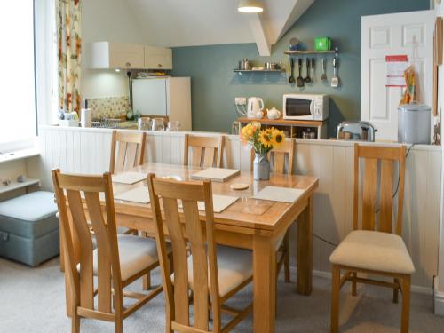 a kitchen and dining room with a wooden table and chairs at Spindrift in Coverack