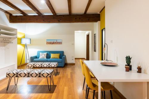 una cucina e un soggiorno con divano blu di Casa Ambrosini Apartments by Wonderful Italy a Bologna