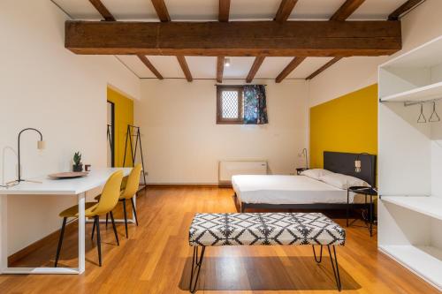 a room with two beds and a table and chairs at Casa Ambrosini Apartments by Wonderful Italy in Bologna