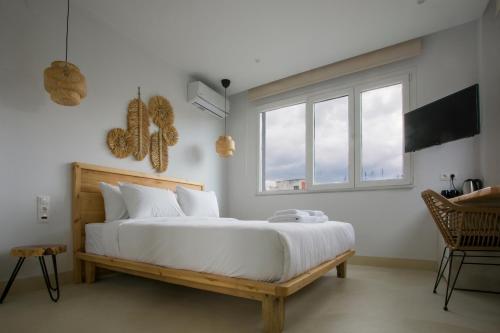 ein Schlafzimmer mit einem großen weißen Bett und einem Fenster in der Unterkunft White Corner in Thessaloniki