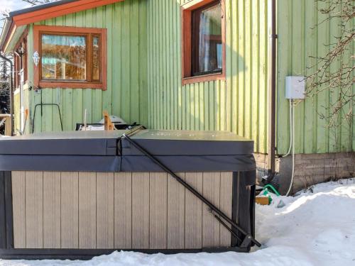 una bañera de hidromasaje frente a una casa en la nieve en Holiday Home Palttala by Interhome, en Viitapohja