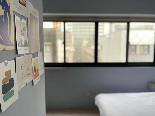 een kamer met een bed en posters aan de muur bij 極旅inn in Taichung