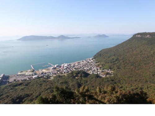 a small town on a hill next to the water at Hotel Bokaiso in Takamatsu