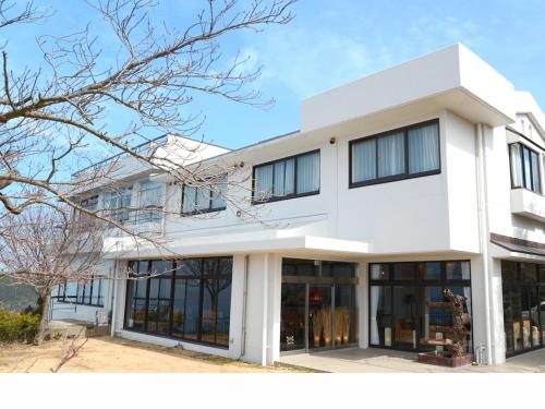 a white building with large windows at Hotel Bokaiso in Takamatsu