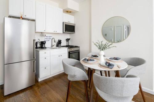 a kitchen with a table with chairs and a refrigerator at Cozy and new fully furnished 1BD/1BR in Park Slope in Brooklyn