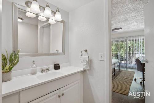 a white bathroom with a sink and a mirror at Walk to Everything - Fun Hyde Park Space King Bed in Austin