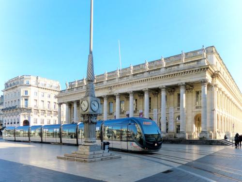 a bus in front of a building with a clock tower at Apartment Les Océanides-14 by Interhome in Lacanau-Océan