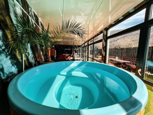 a large blue tub in a room with windows at TRANSILVANIA BLISS COTTAGE in Someşu Rece