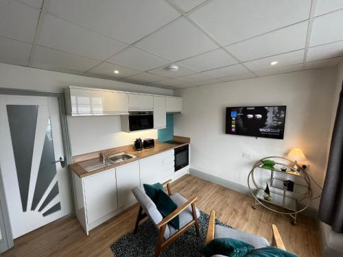 a room with a kitchen and a living room at Sunray Suites in Barmouth