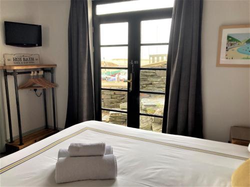 um quarto com uma cama e uma grande janela em Sunray Apartments em Barmouth