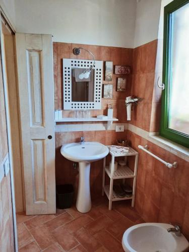 a bathroom with a sink and a mirror and a toilet at La Lomita in Santa Marinella