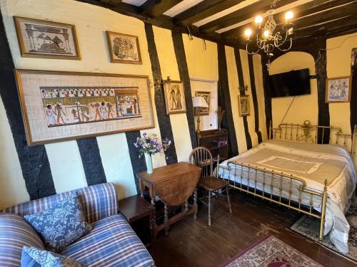 The Bridge Street Historic Guest House في سودبيري: غرفة نوم بسرير وطاولة واريكة