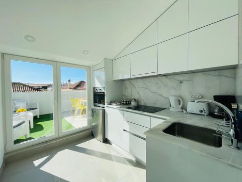 a kitchen with a sink and a view of a patio at Central Tiled Apartment in Aveiro