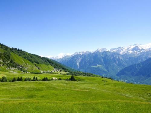 a green hill with snow covered mountains in the background at Apartment Vista Valle by Interhome in Castro