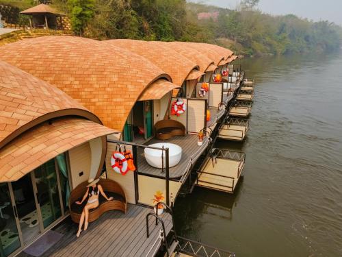 une rangée de bateaux sur une rivière dans l'établissement VeeVaree Riverkwai Resort, à Ban Kaeng Raboet