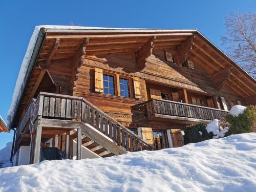 une cabane en rondins avec de la neige devant elle dans l'établissement Apartment Les Hivernants - EG links by Interhome, à Gstaad
