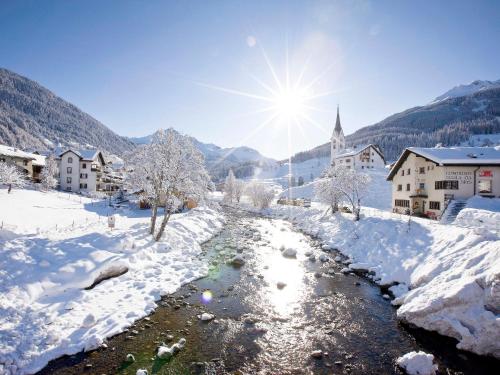 a village in the snow with a river at Apartment Surses Alpin-2 by Interhome in Savognin
