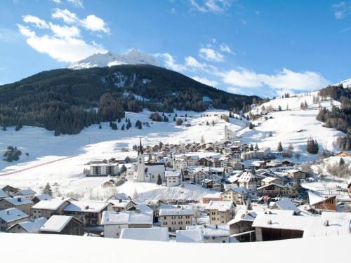 a town covered in snow with a mountain in the background at Apartment Surses Alpin-2 by Interhome in Savognin