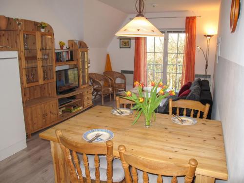 a kitchen and living room with a wooden table and chairs at Apartment Gollwitzer Park - Insel Poel-7 by Interhome in Gollwitz