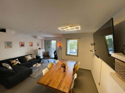 a living room with a wooden table and a black couch at Casa-Mont-Roig, new renovated, 5 minutes to beach in Montroig