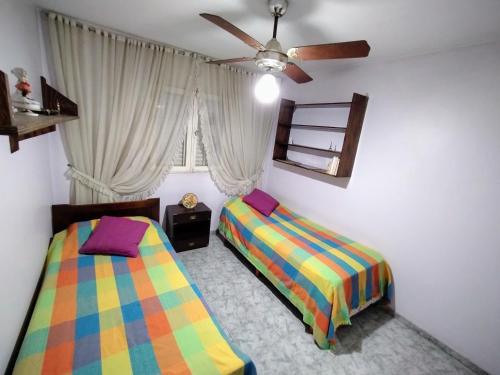 1 dormitorio con 2 camas y ventilador de techo en LA CASA DE LA PARRA en Godoy Cruz