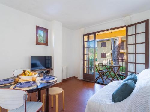 un salon avec une table et une télévision dans l'établissement Apartment Saint Clair by Interhome, au Lavandou