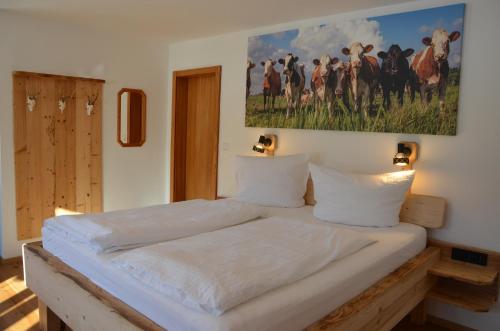 uma cama num quarto com uma pintura na parede em Pension Wötzinghof em Kirchberg in Tirol