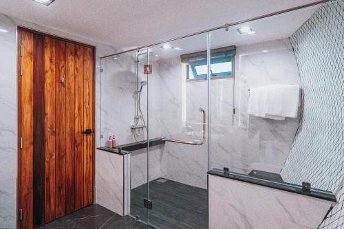 a bathroom with a shower with a glass door at VeeVaree Riverkwai Resort in Ban Kaeng Raboet