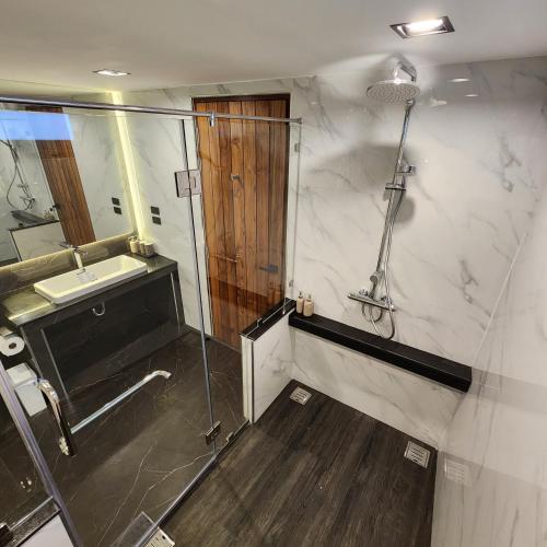 a bathroom with a shower and a sink and a shower at VeeVaree Riverkwai Resort in Ban Kaeng Raboet