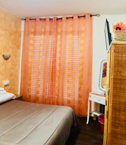a bedroom with an orange curtain and a bed at Affittacamere Selene in Sanremo