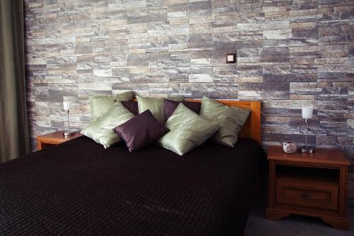 a bedroom with a brick wall and a bed with pillows at Citihost Károly körút in Budapest