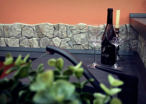 a bottle of wine and two glasses on a table at Citihost K&aacute;roly k&ouml;r&uacute;t in Budapest