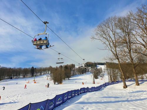 a group of people riding a ski lift in the snow at Holiday Home Holiday Hill 39 by Interhome in Lauterwasser