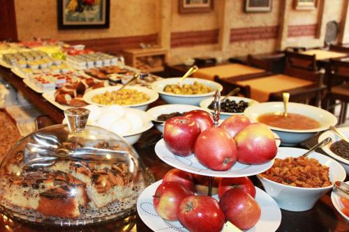 a buffet of food with apples on plates on a table at Hotel SultanHill in Istanbul