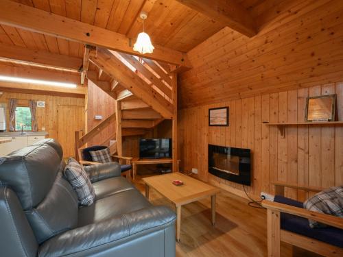 a living room with a couch and a tv in a cabin at Chalet Birchwood Cottage by Interhome in Inverness