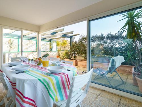 una sala da pranzo con tavolo e vista sul patio di Apartment Les Jardins Victoria-1 by Interhome a Biarritz