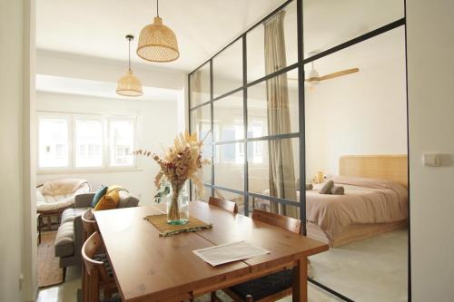ein Wohnzimmer mit einem Tisch und ein Schlafzimmer in der Unterkunft Ocean View Ha Apartment in Cádiz