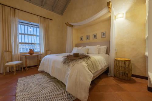 um quarto com uma grande cama branca e uma janela em Moet Cartagena Hotel Boutique em Cartagena de Indias