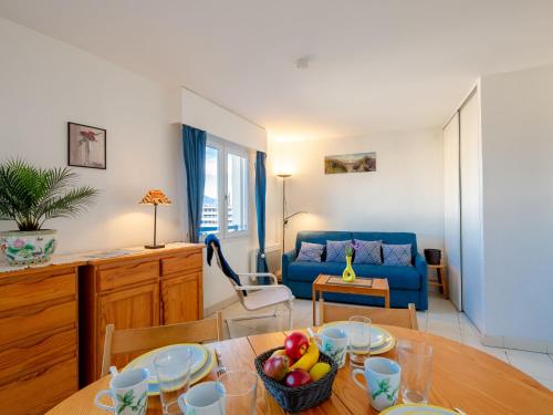 un salon avec une table et un canapé bleu dans l'établissement Studio Résidence Aigue Marine-2 by Interhome, à Fréjus