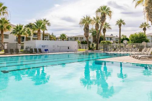 a large swimming pool with palm trees and buildings at Tuscan Desert Vista #2001 condo in St. George